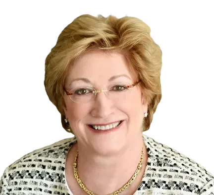 A woman wearing glasses and a necklace is smiling for the camera.