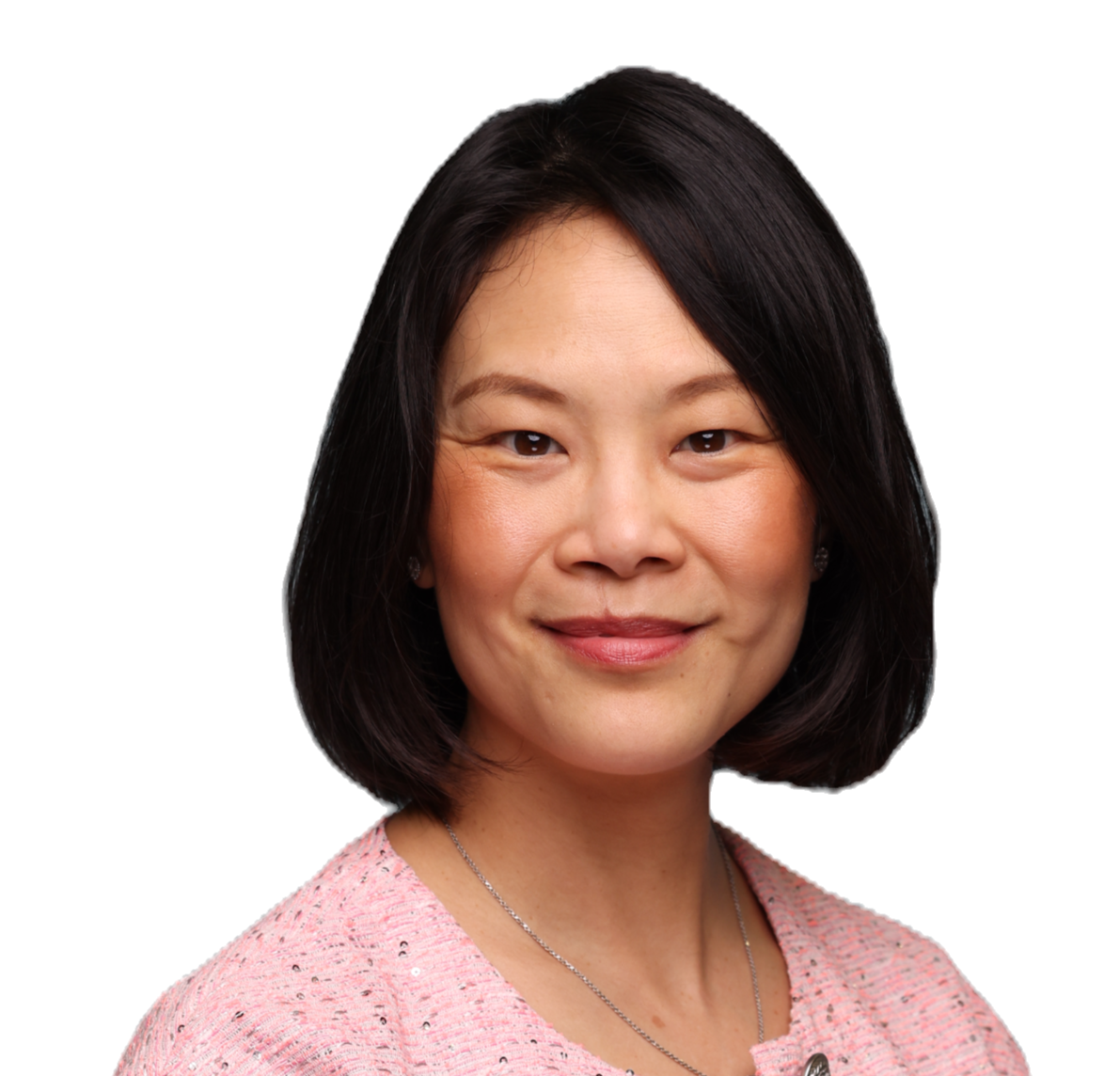 A woman wearing a pink shirt and necklace smiles for the camera