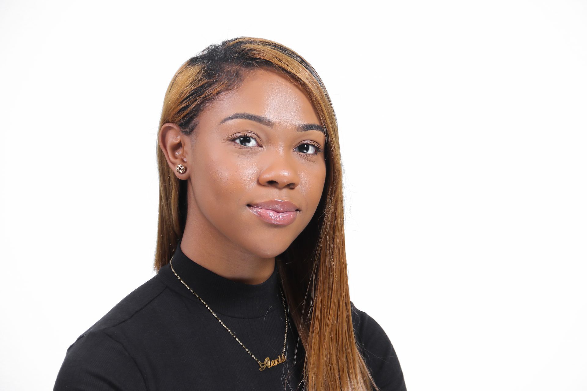 The woman is wearing a black shirt and a gold necklace.
