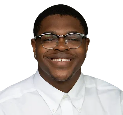 A man wearing glasses and a white shirt is smiling for the camera.