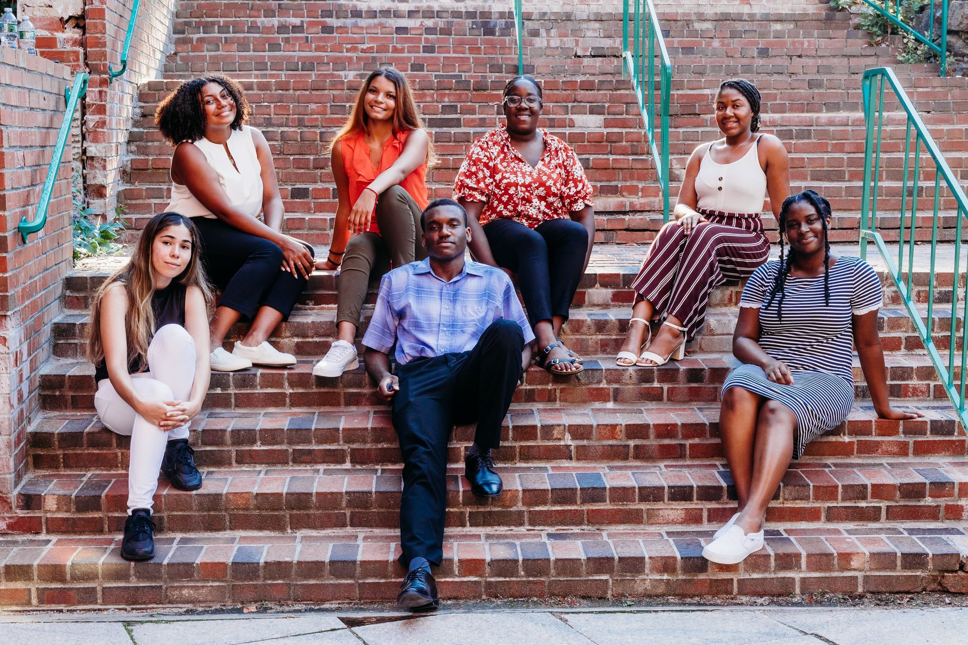 A group of people are sitting on a set of stairs.