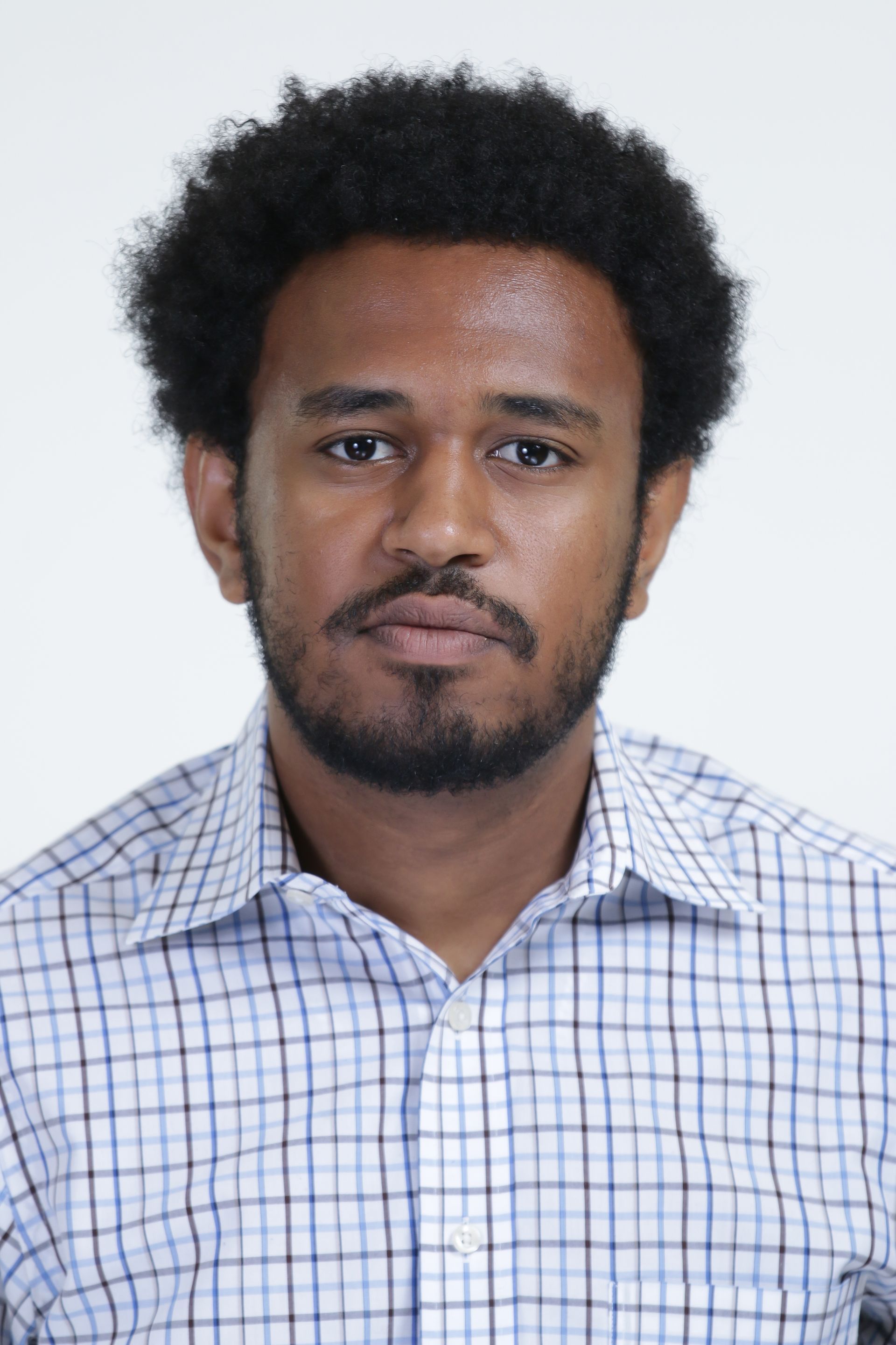A man with a beard is wearing a plaid shirt