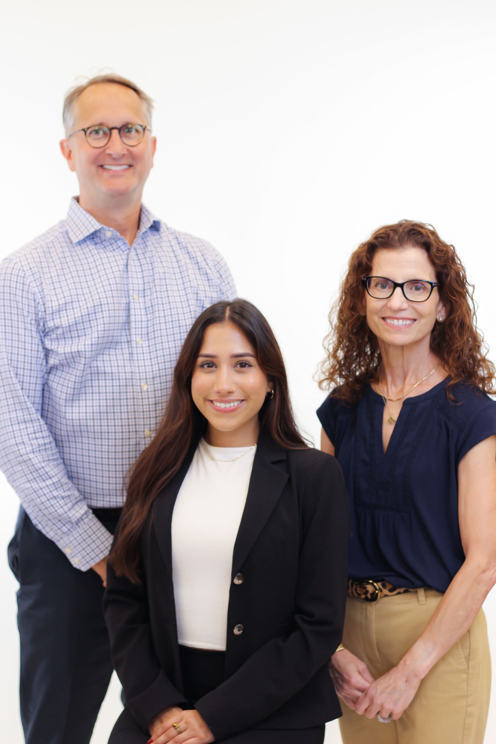A man and two women are posing for a picture together.