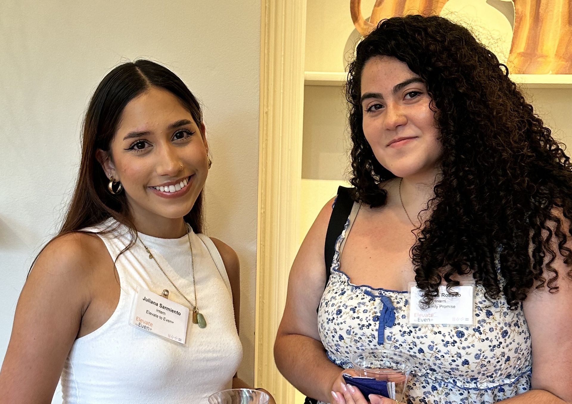 Two women are standing next to each other and smiling for the camera.