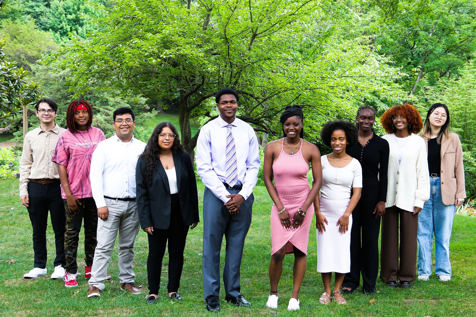 A group of people are posing for a picture in a park.