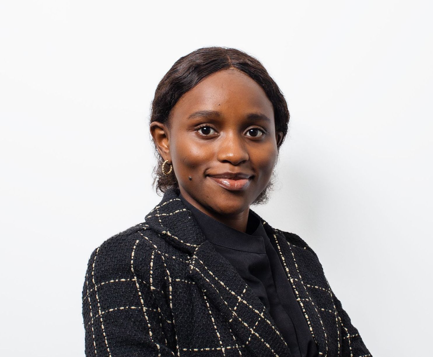 A woman in a black jacket is smiling for the camera.
