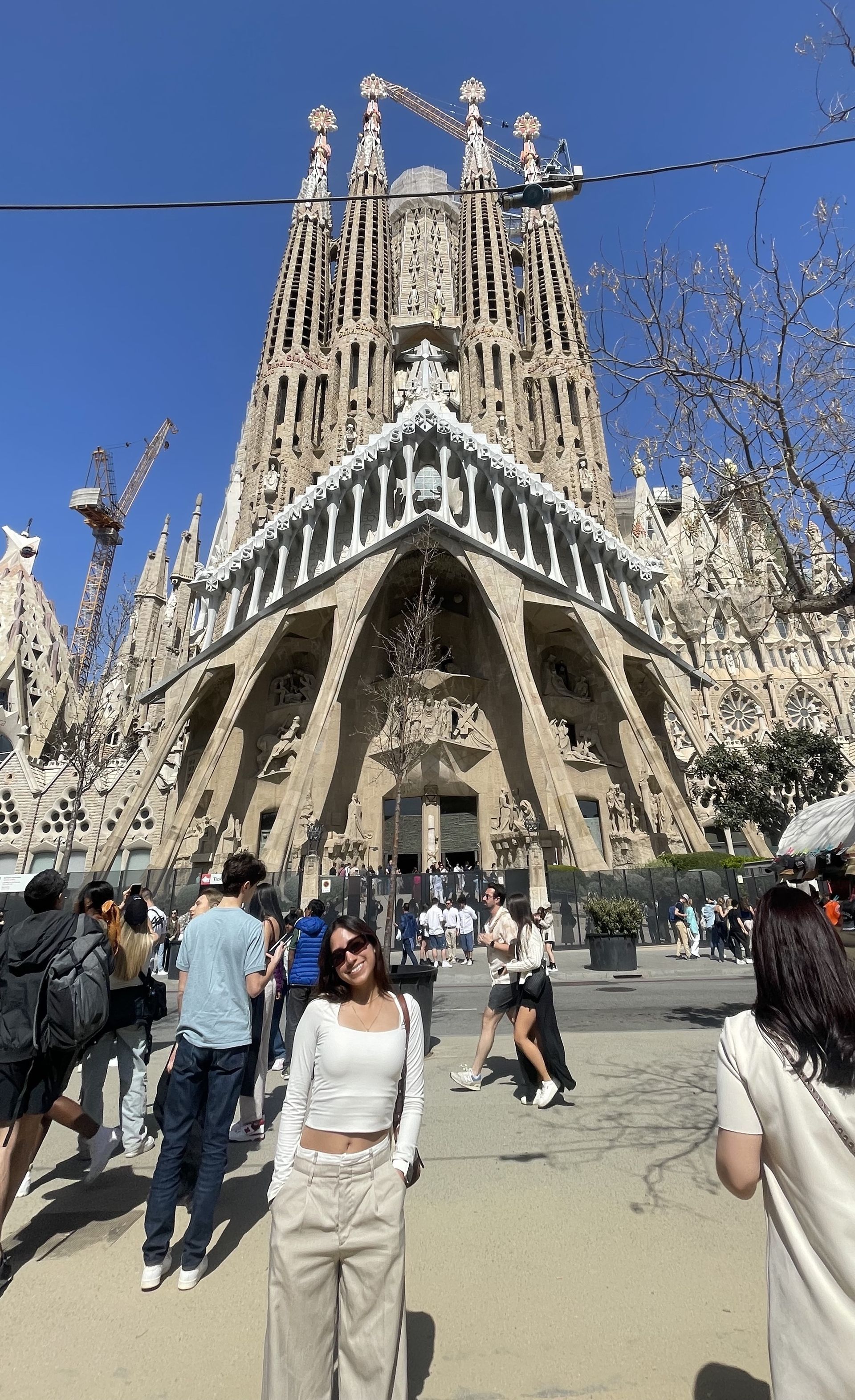 A woman is standing in front of a large building.