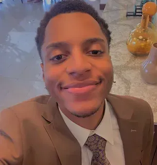 A man in a suit and tie is smiling for the camera.