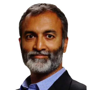 A man with a beard is wearing a suit and a blue shirt.