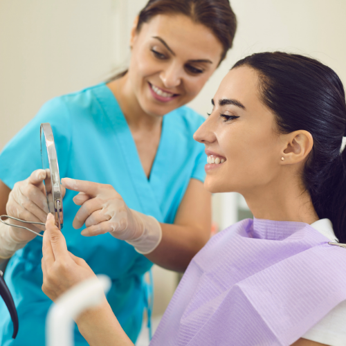 Woman smiling in front of mirror | Get convenient same-day crowns in Overland Park 66221.
