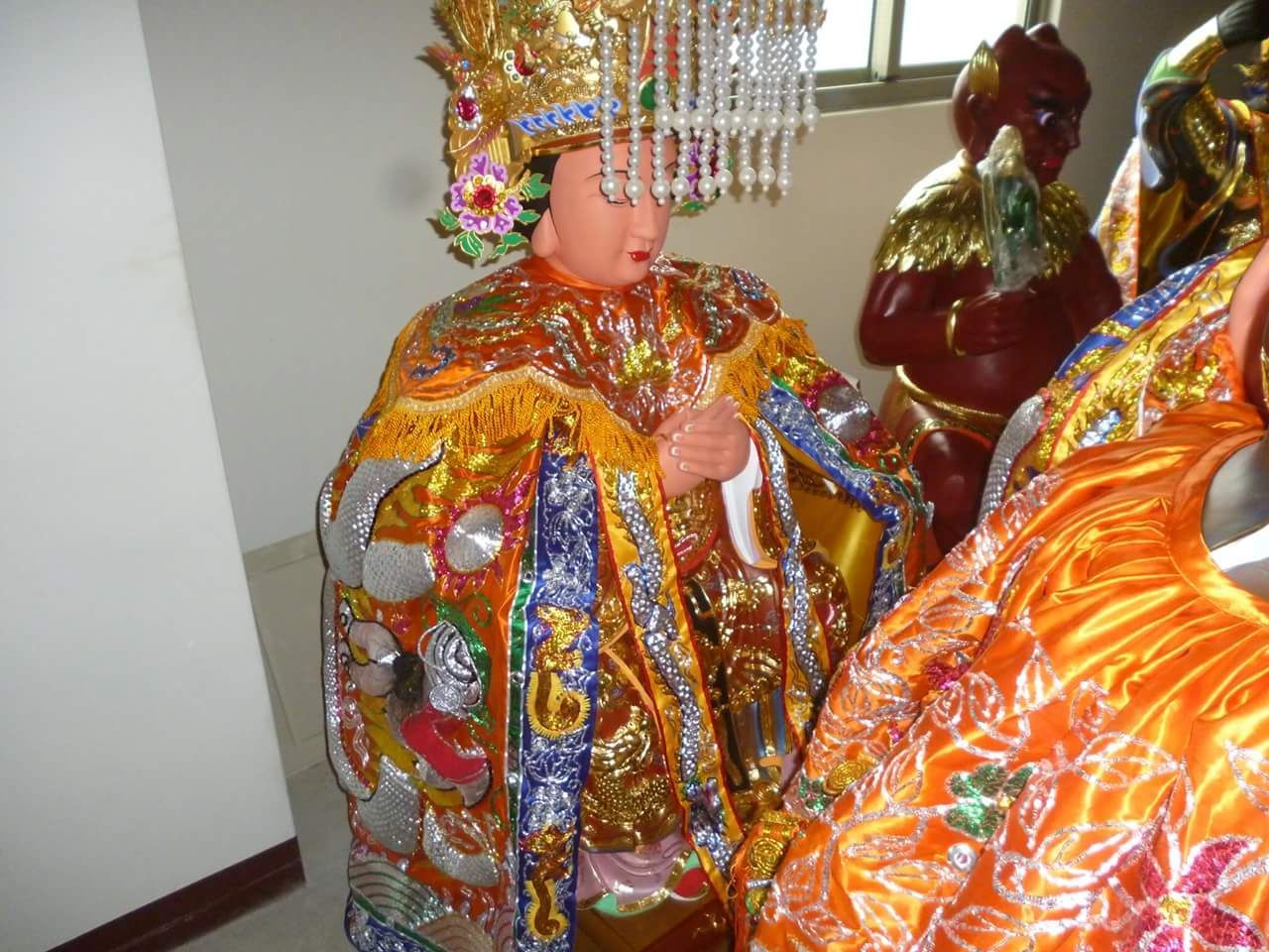 室內一尊色彩繽紛的祭祀雕像，身穿華麗的金色、橙色和藍色長袍。