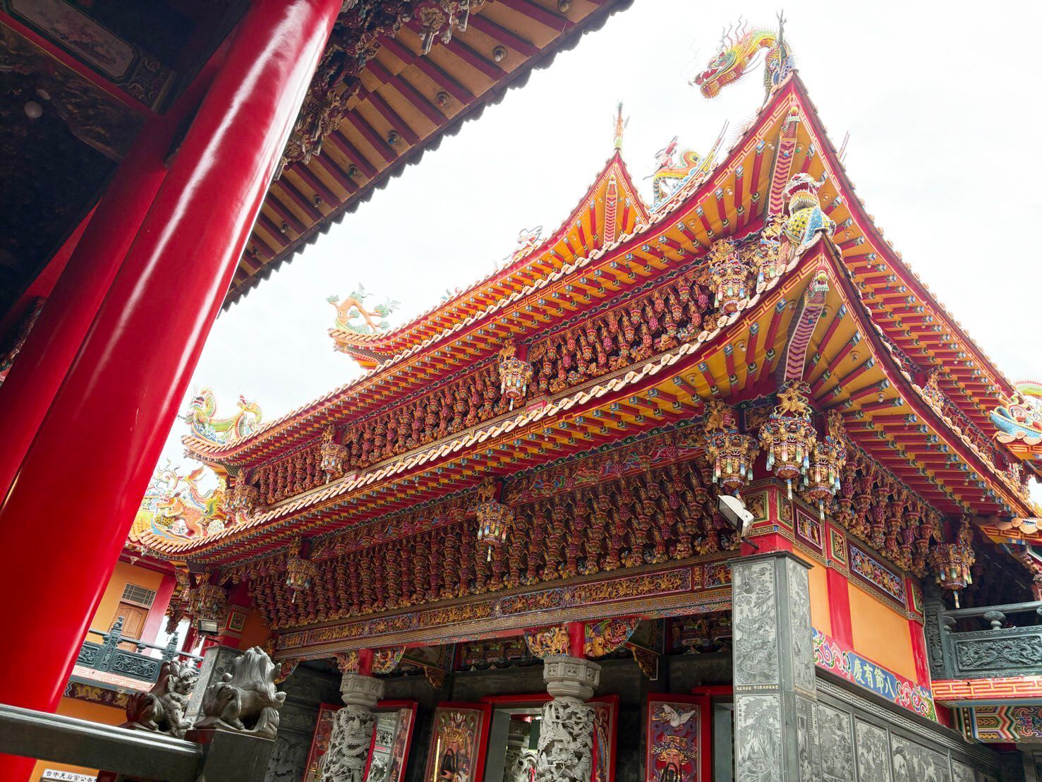 華麗的紅金相間中國式寺廟，屋頂和柱子均有雕刻，位於有頂走廊之下。