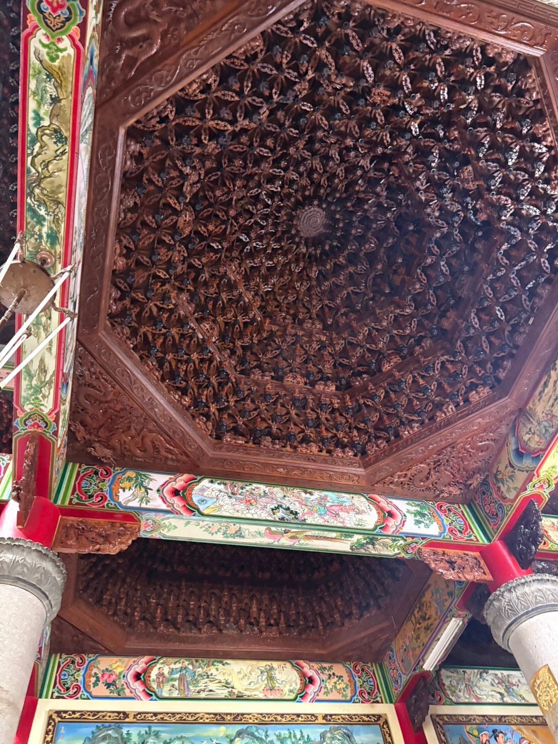 歷史建築內部裝潢華麗，雕刻木質天花板，搭配色彩繽紛的花卉橫樑和立柱。