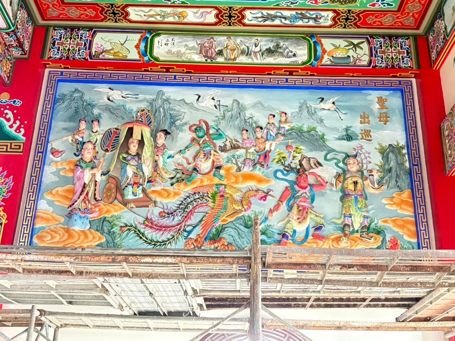 紅金相間的天花板上繪有色彩繽紛的寺廟壁畫，描繪了印度教神靈和神話人物。
