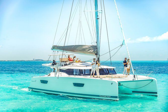 Una pareja está parada en un velero en el océano.