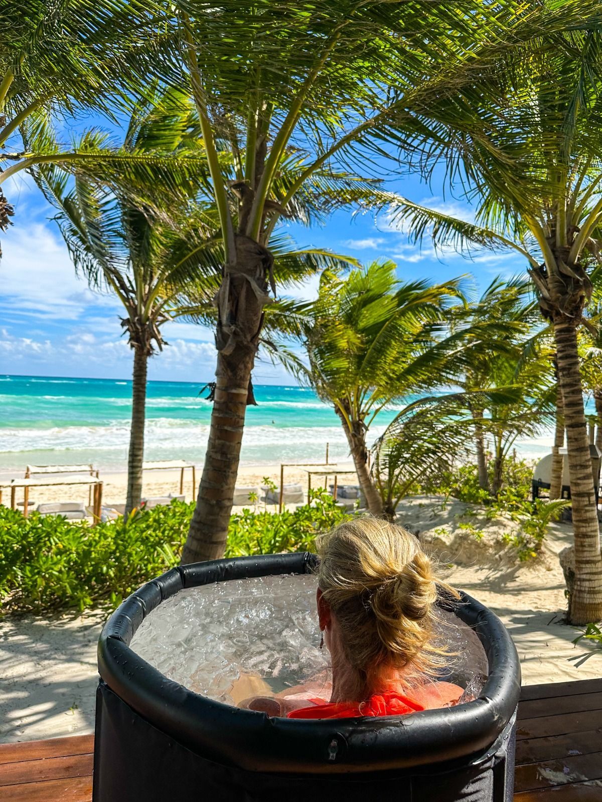 Una mujer está sentada en un jacuzzi mirando el océano.