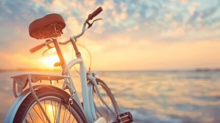 Una bicicleta está estacionada en la playa al atardecer.