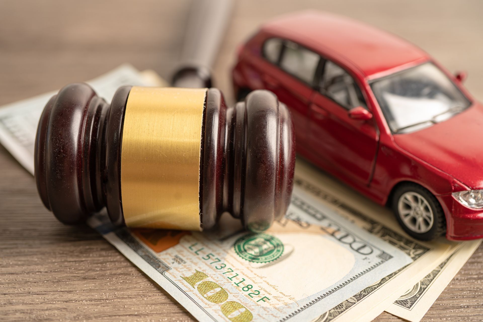 Car accident attorney concept with gavel, money, and vehicle model