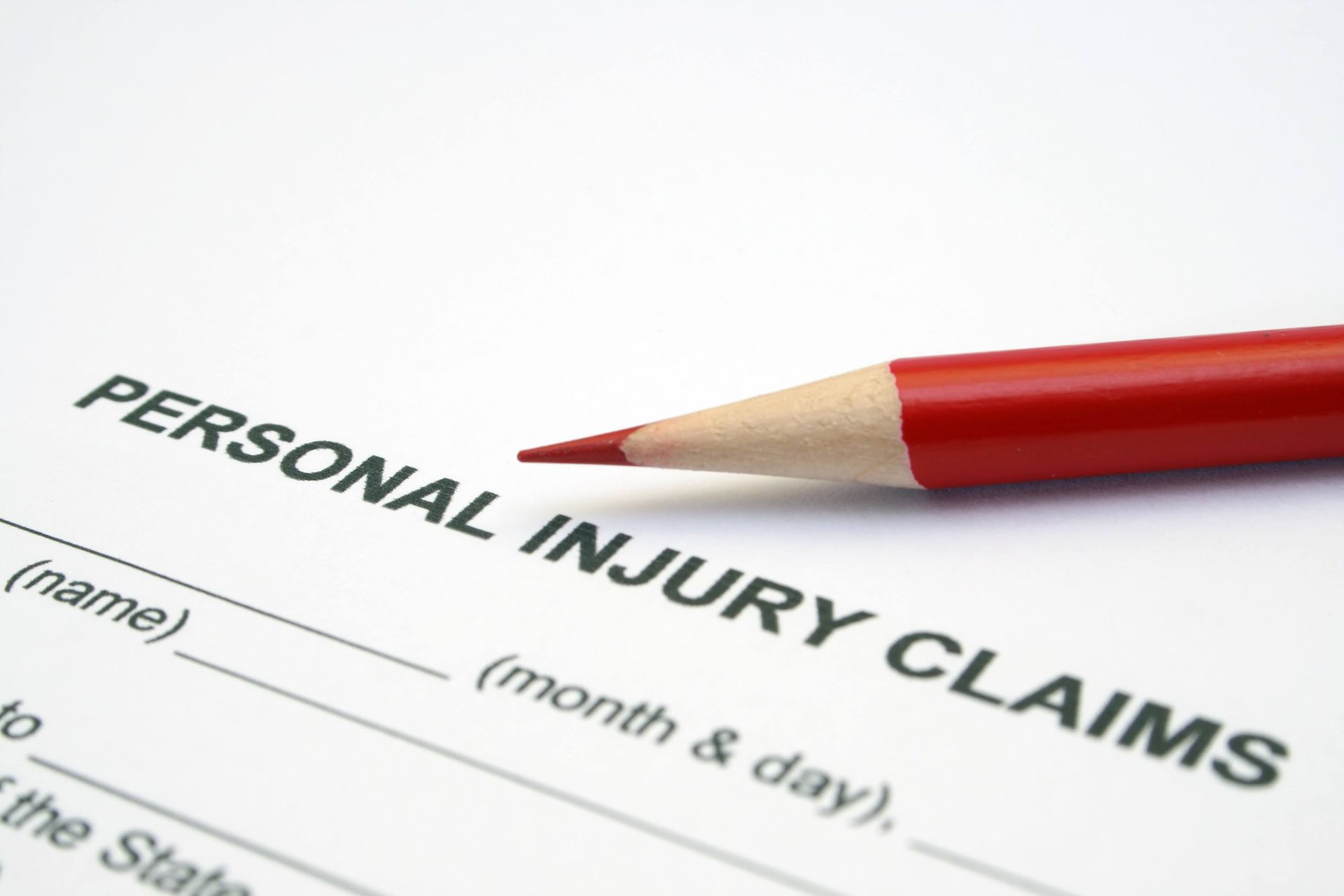 A red pencil is sitting on top of a personal injury claims form
