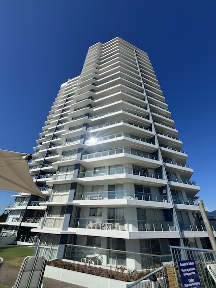 Sparkling tall modern apartment building with white balconies against a blue sky— Jackson's Window Cleaning in Nerang, QLD