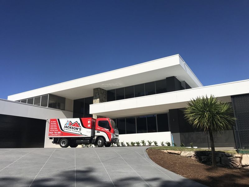 Red and White Moving Truck in Front of a Modern, Two-story White — Jackson's Window Cleaning in Nerang, QLD