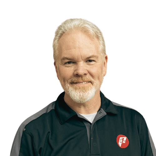 Man with gray beard, wearing a black and gray polo shirt, smiles at the camera.