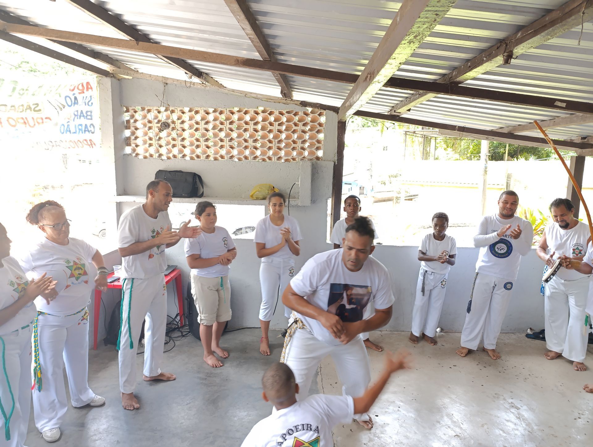 Um grupo de pessoas está em volta de um homem de camisa branca.