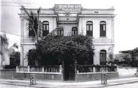 Uma foto em preto e branco de um grande edifício na esquina de uma rua.