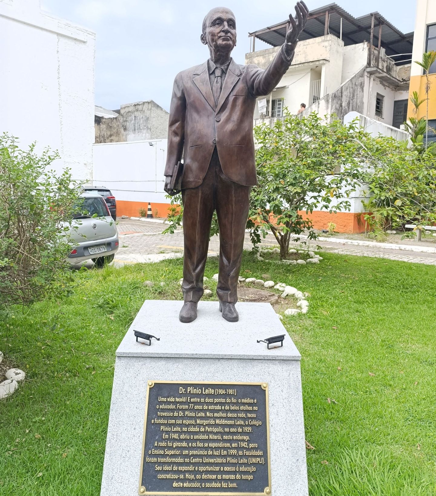 Uma estátua de um homem de terno está em um parque.