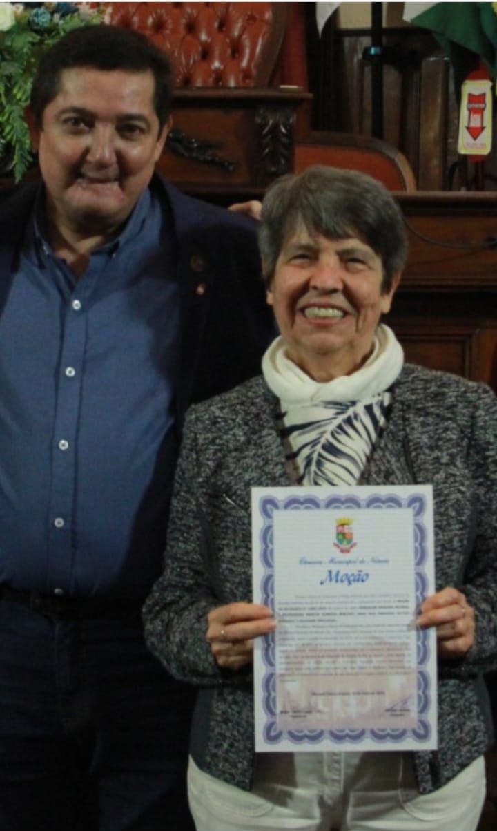 Um homem e uma mulher estão posando para uma foto e a mulher está segurando um certificado