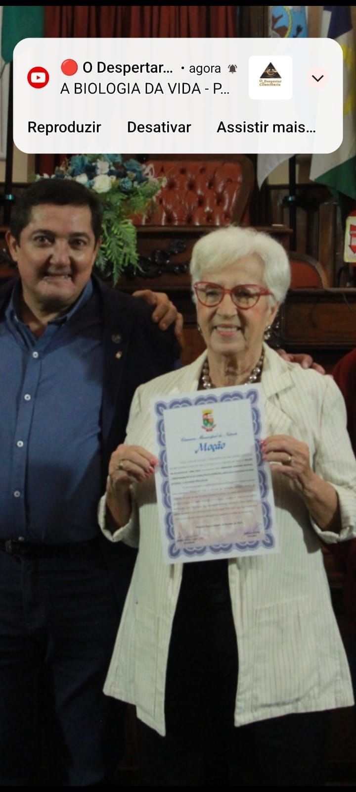 Um homem e uma mulher estão de pé, um ao lado do outro, segurando um certificado.
