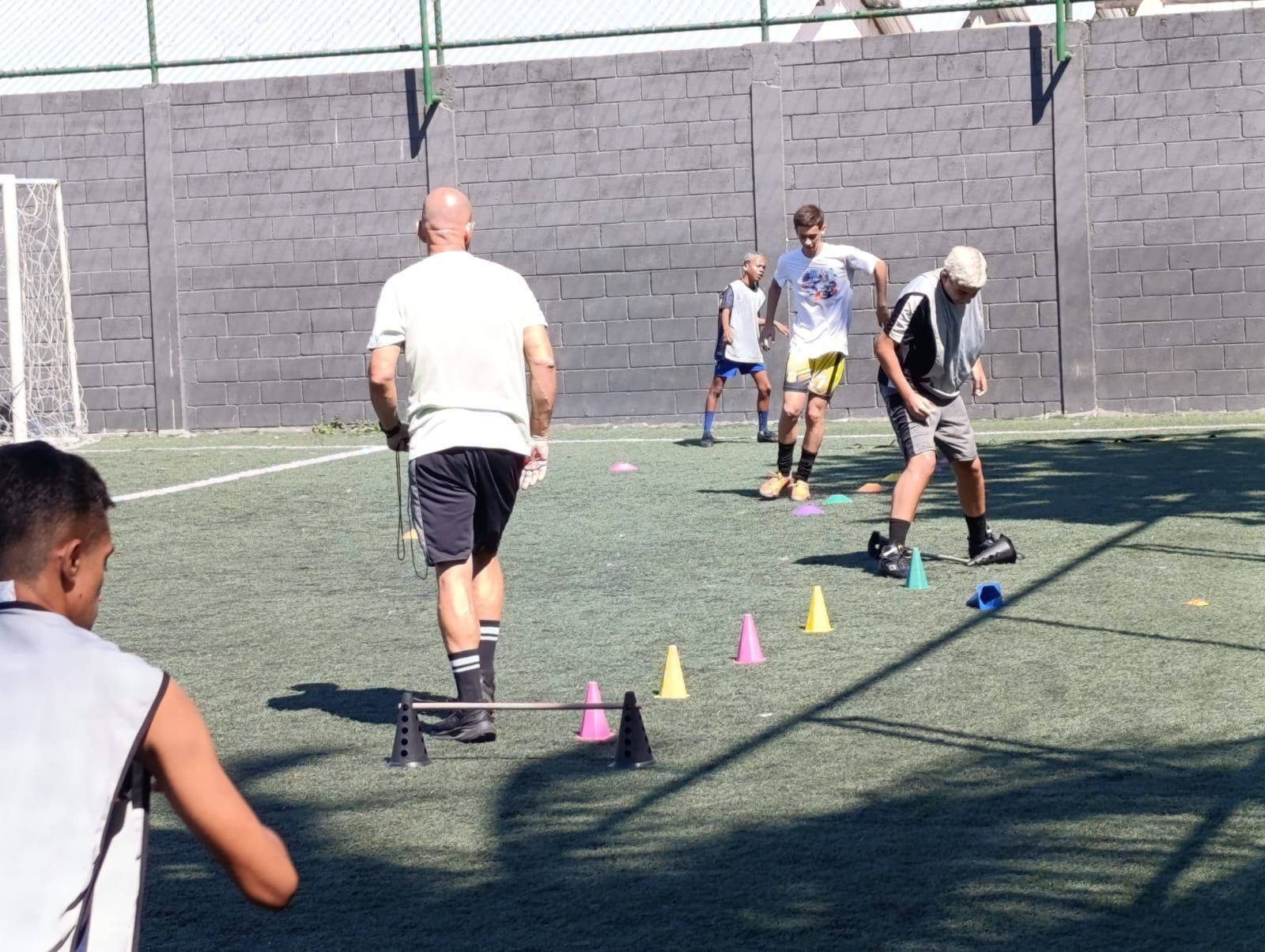 Um grupo de pessoas está jogando futebol em um campo