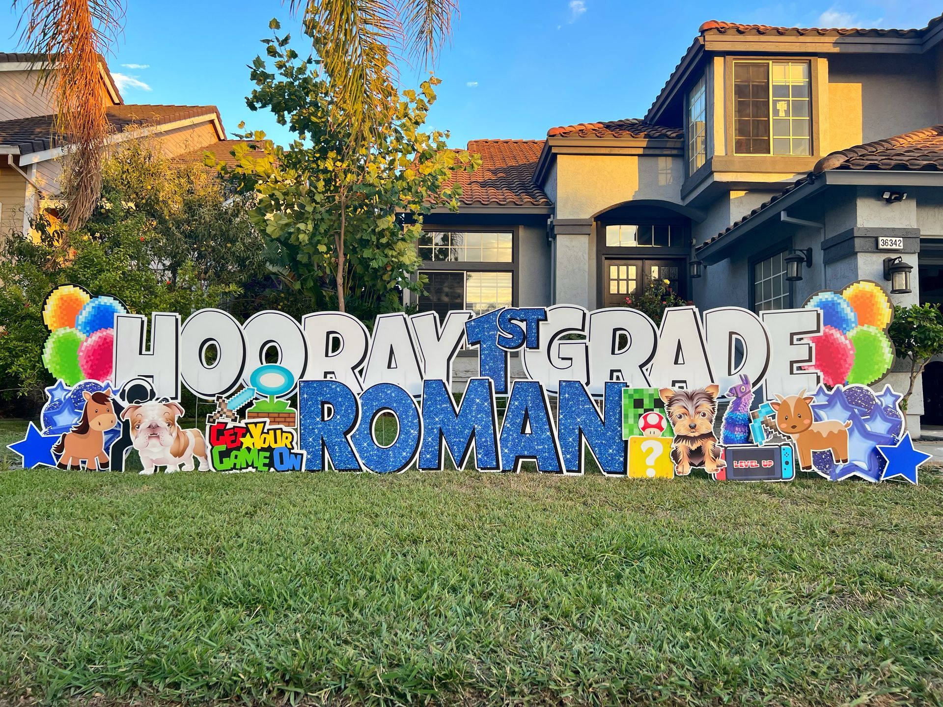 A themed/personalized display spelling out Hooray 1st Grade for Roman. 