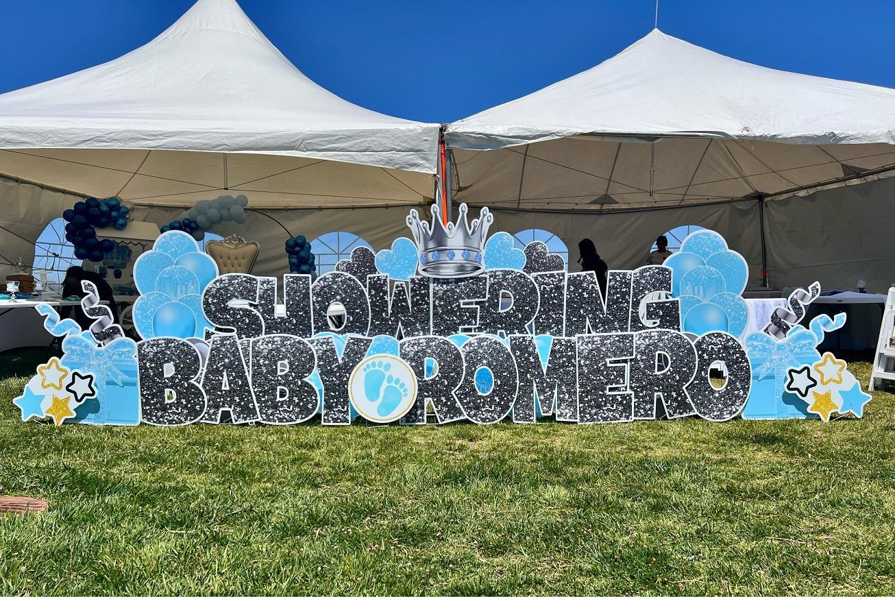 Baby shower display stating Showering Baby Romero. Baby blue and silver are the colors represented. 