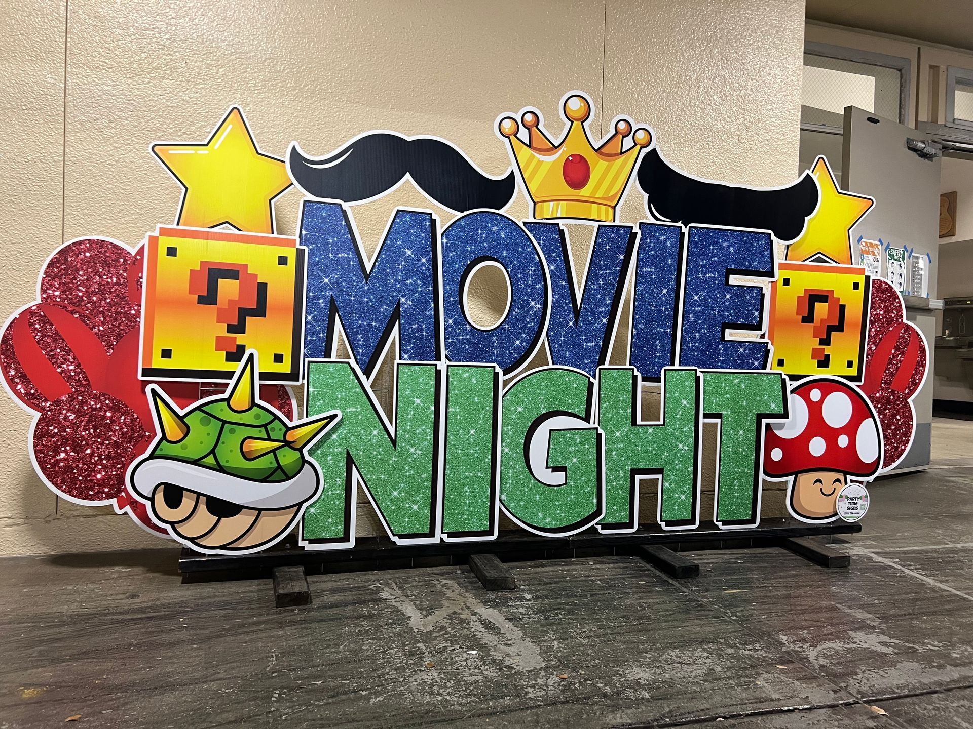 Image of a movie night display at a school event. Includes super mario theme. 