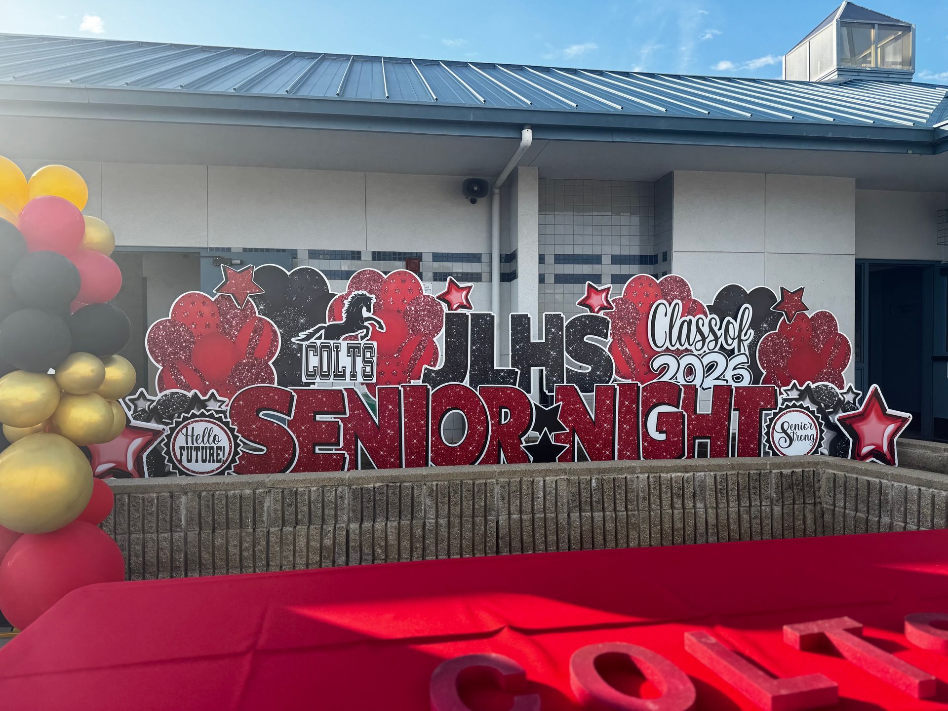 Image of JLHS senior night water polo team celebration in red and black. 