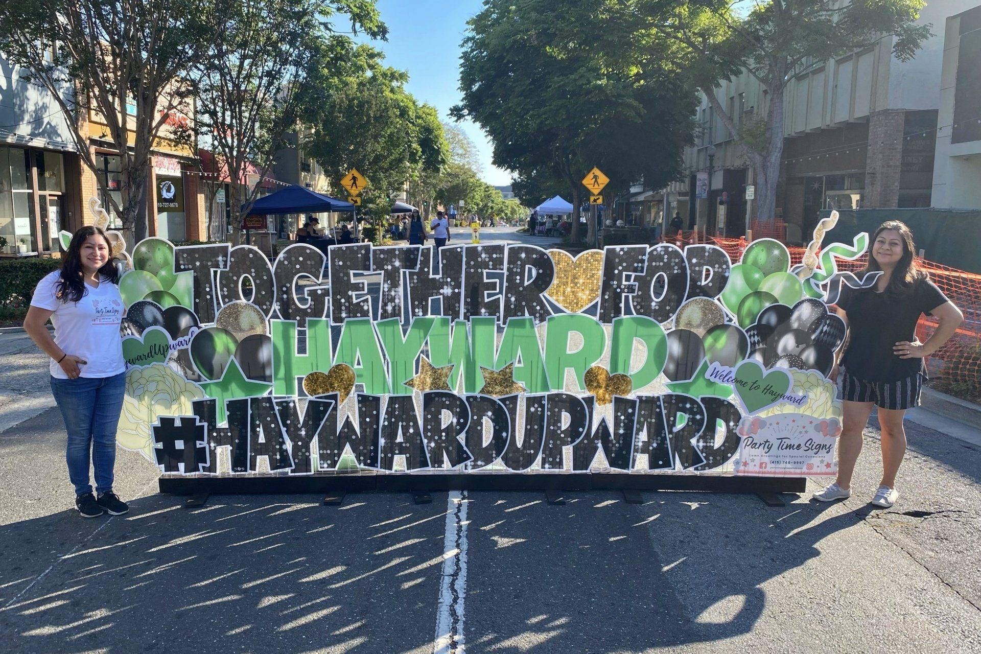 Image of the Party Time Signs team and a sign with the statement Together For Hayward, Hayward Upward appears.