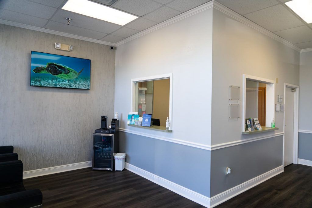 There is a painting on the wall above the counter in the waiting room.