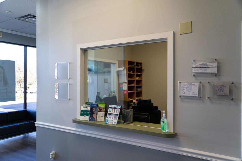 A dental office reception area with a window and a counter.