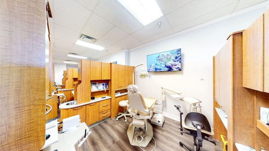 A dental office with a dental chair and cabinets.