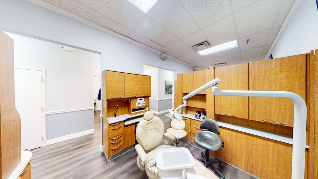 A dental office with a dental chair and cabinets.