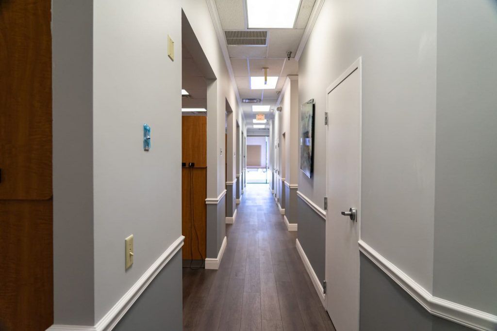 A long hallway with wooden floors and white walls