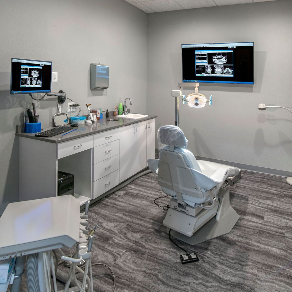 Fillings A dental office with a dental chair and two monitors