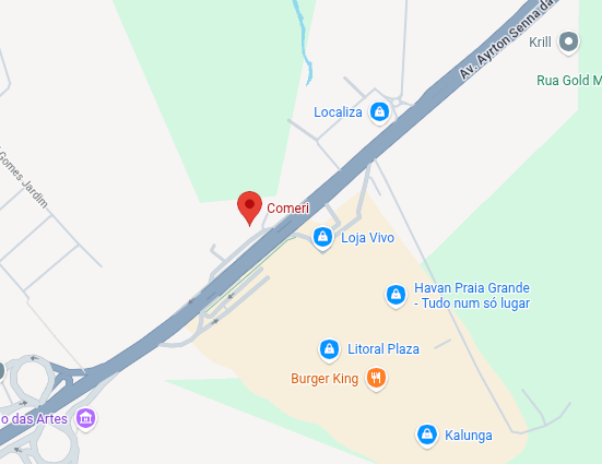 Mapa mostrando um marcador vermelho de localização próximo a uma estrada diagonal e nomes de empresas nas proximidades.