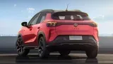 SUV compacto vermelho visto por trás em uma estrada à beira-mar.
