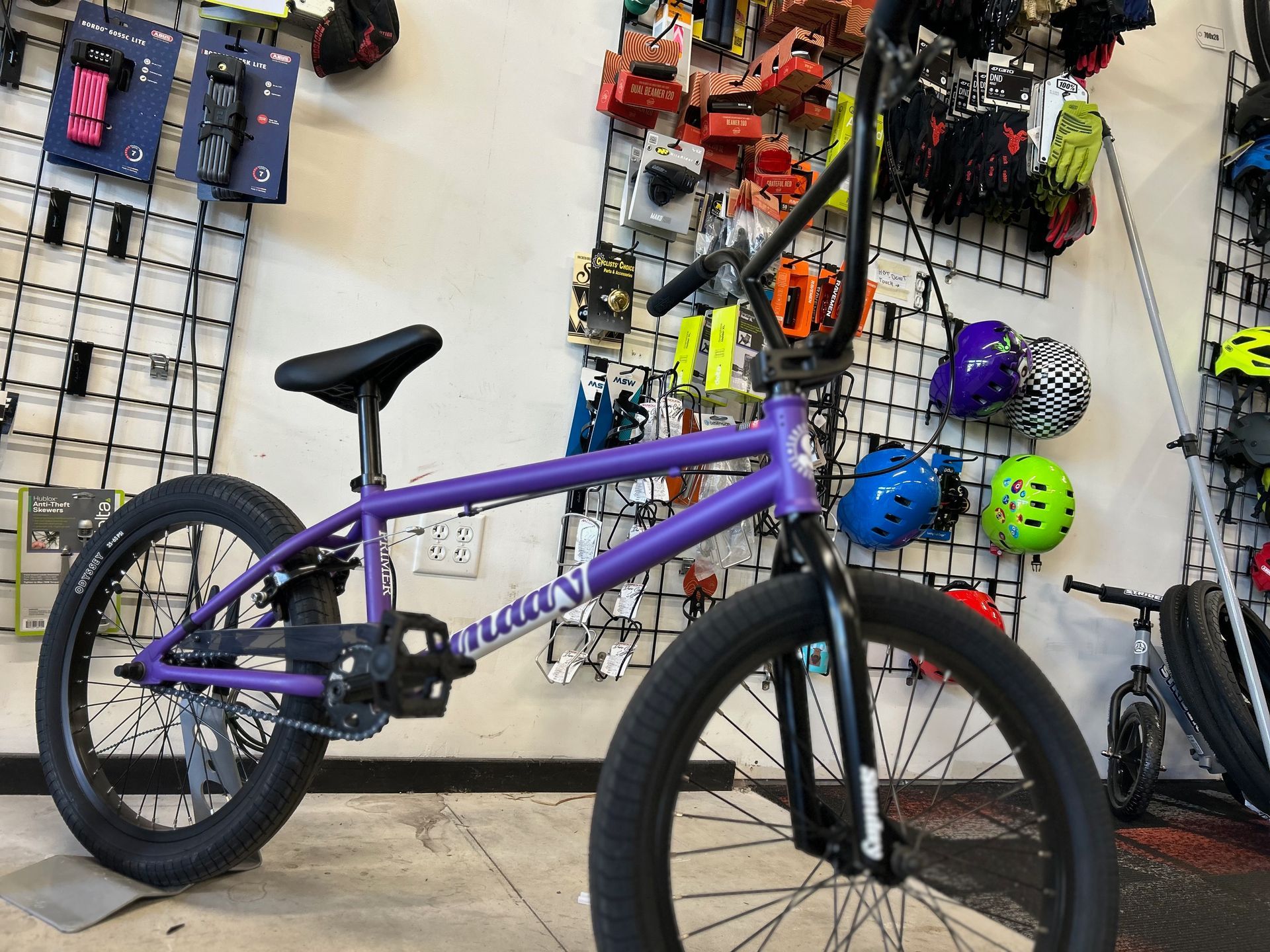 A purple bmx bike is parked in a store.