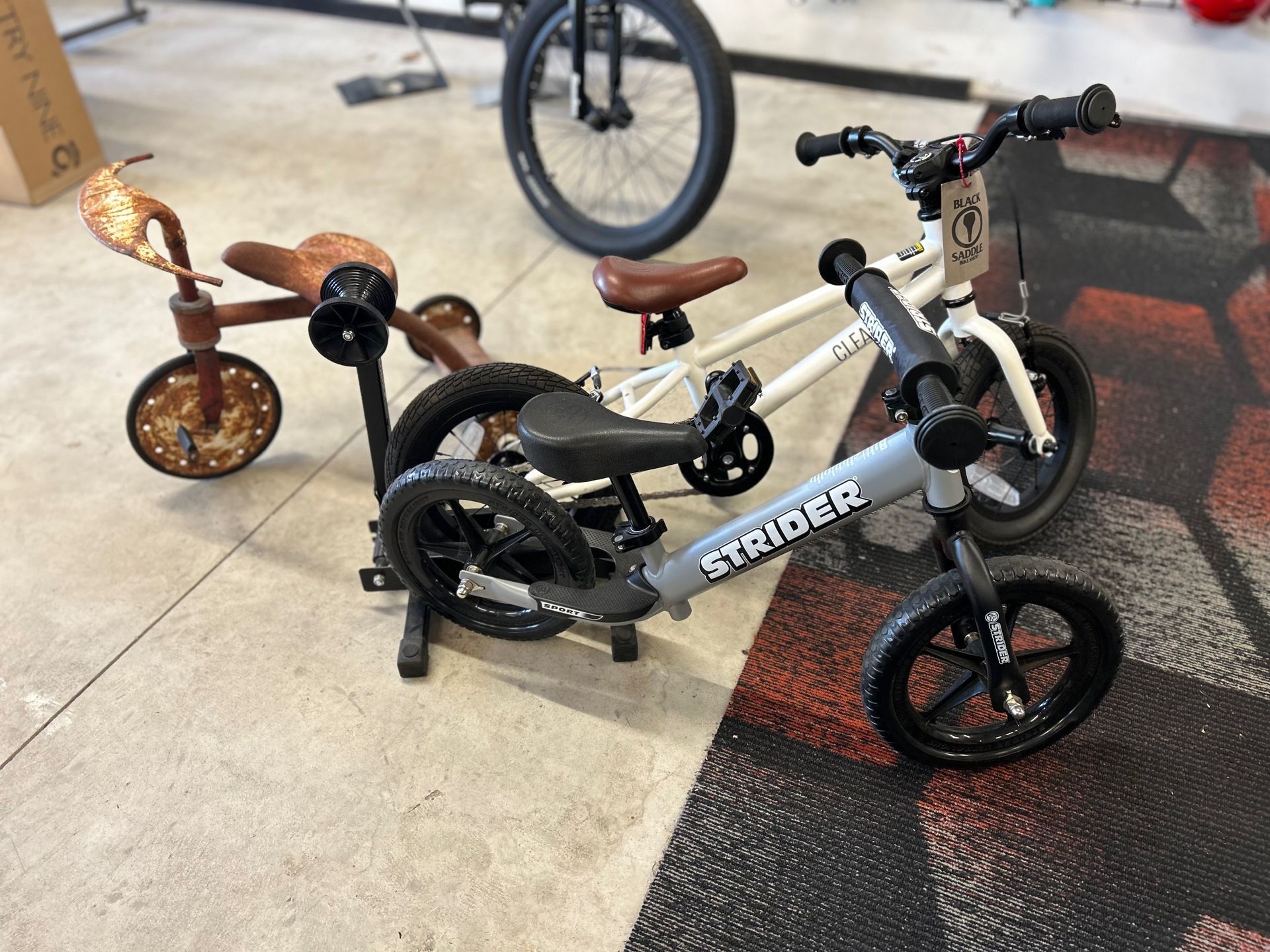 Three strider bikes are sitting next to each other in a garage.