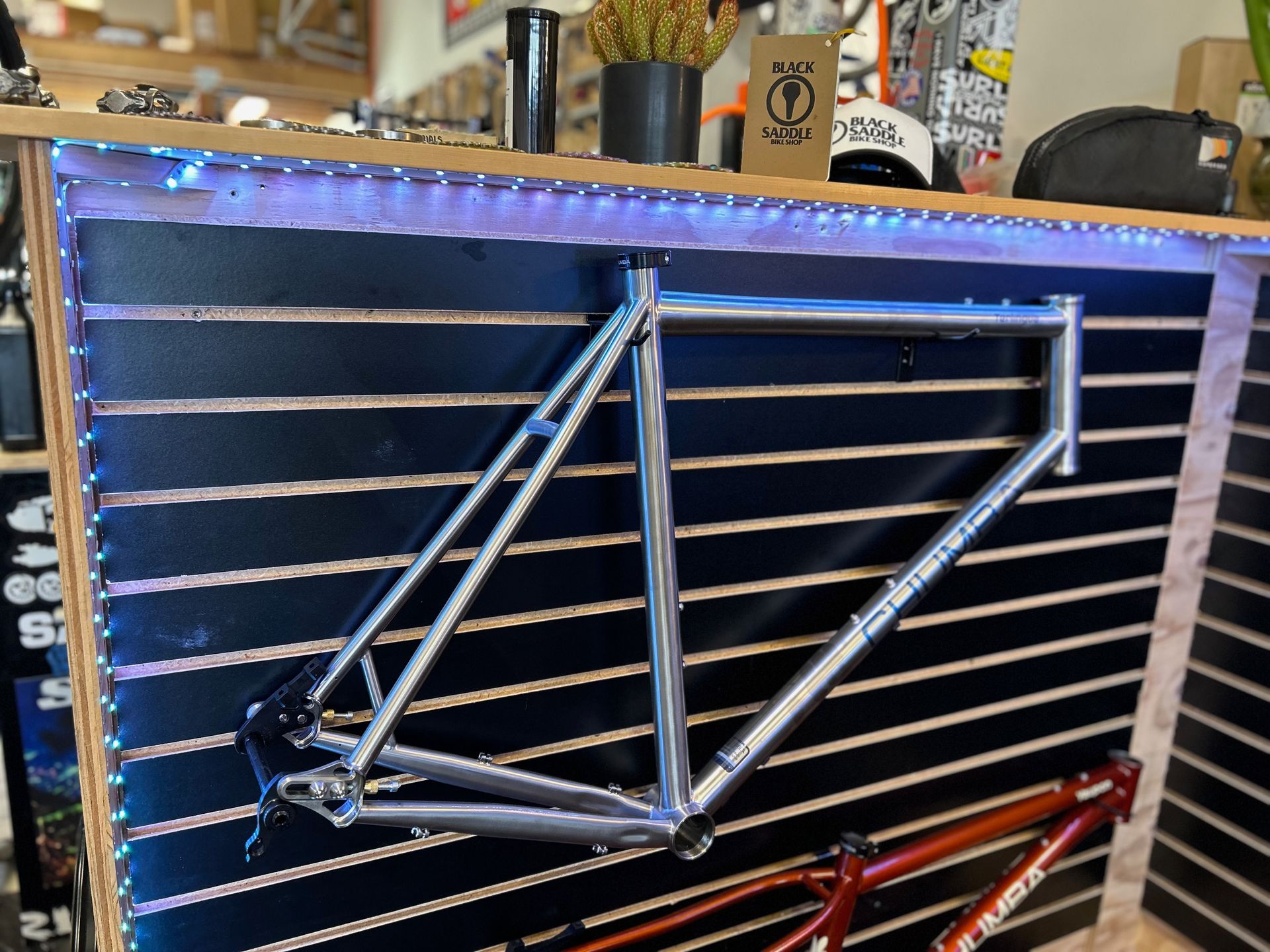 A bicycle frame is hanging on a wall in a store