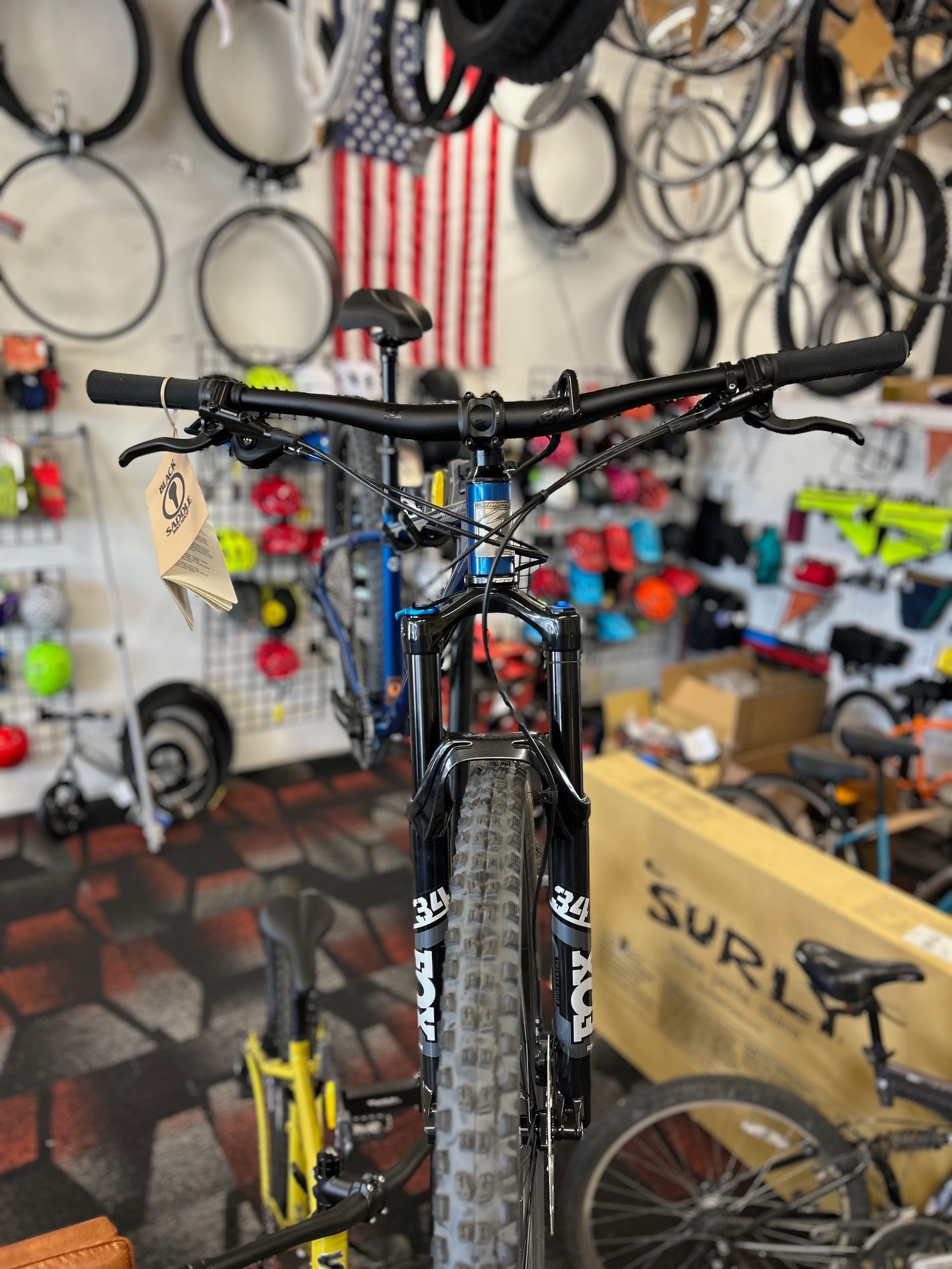 A blue bicycle is sitting in a bicycle shop.