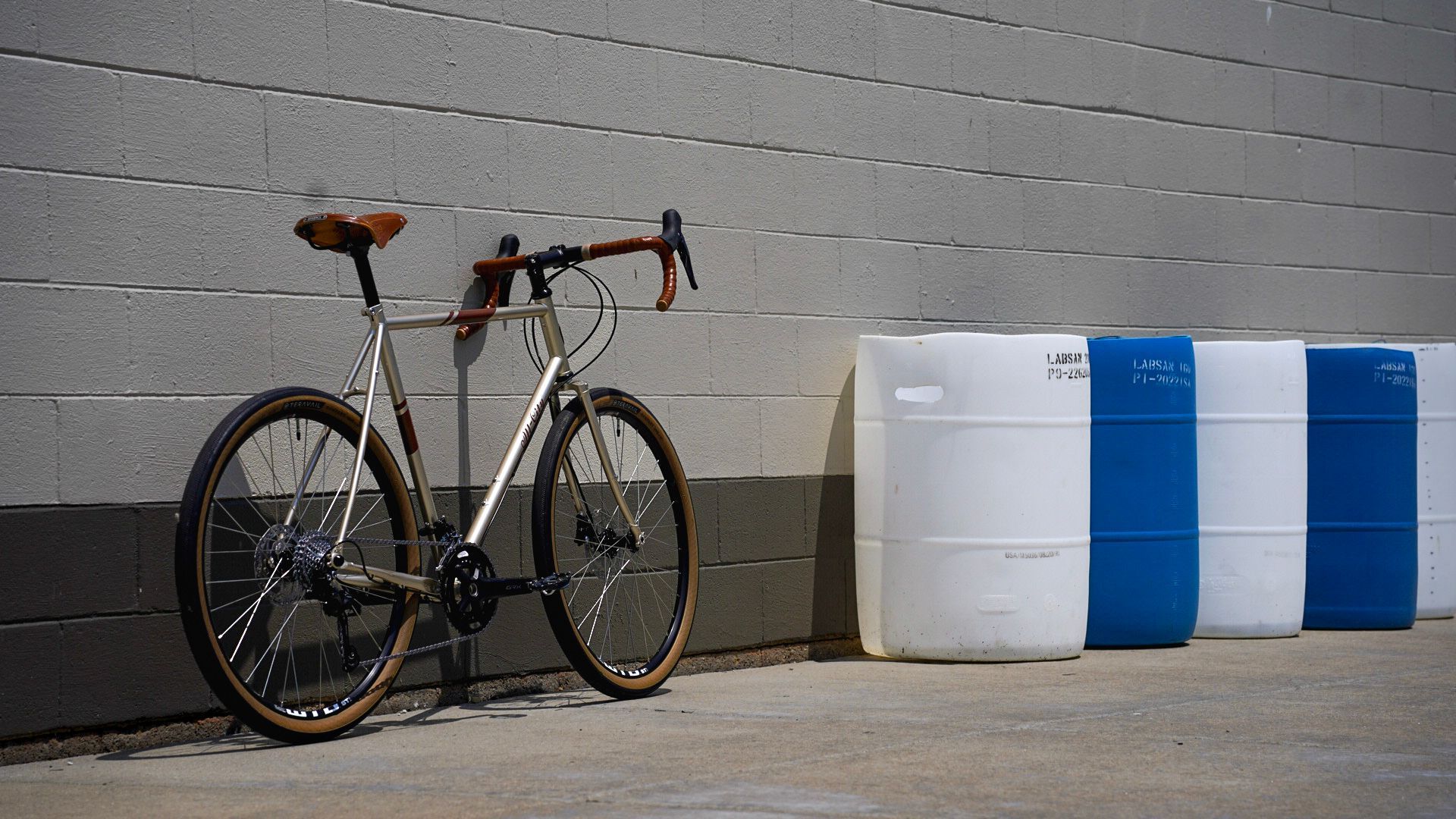 A bicycle is parked in front of a brick wall.